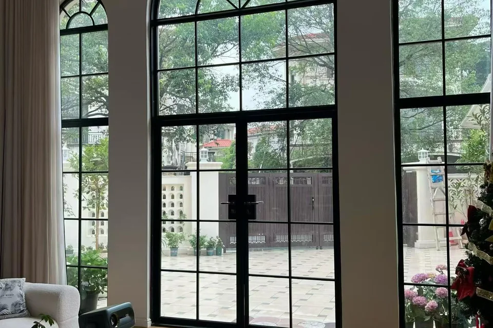 住宅客厅内的黑框拱形法式窗与玻璃双开门